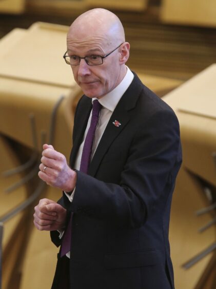 photo shows John Swinney in the debating chamber at the Scottish Parliament.