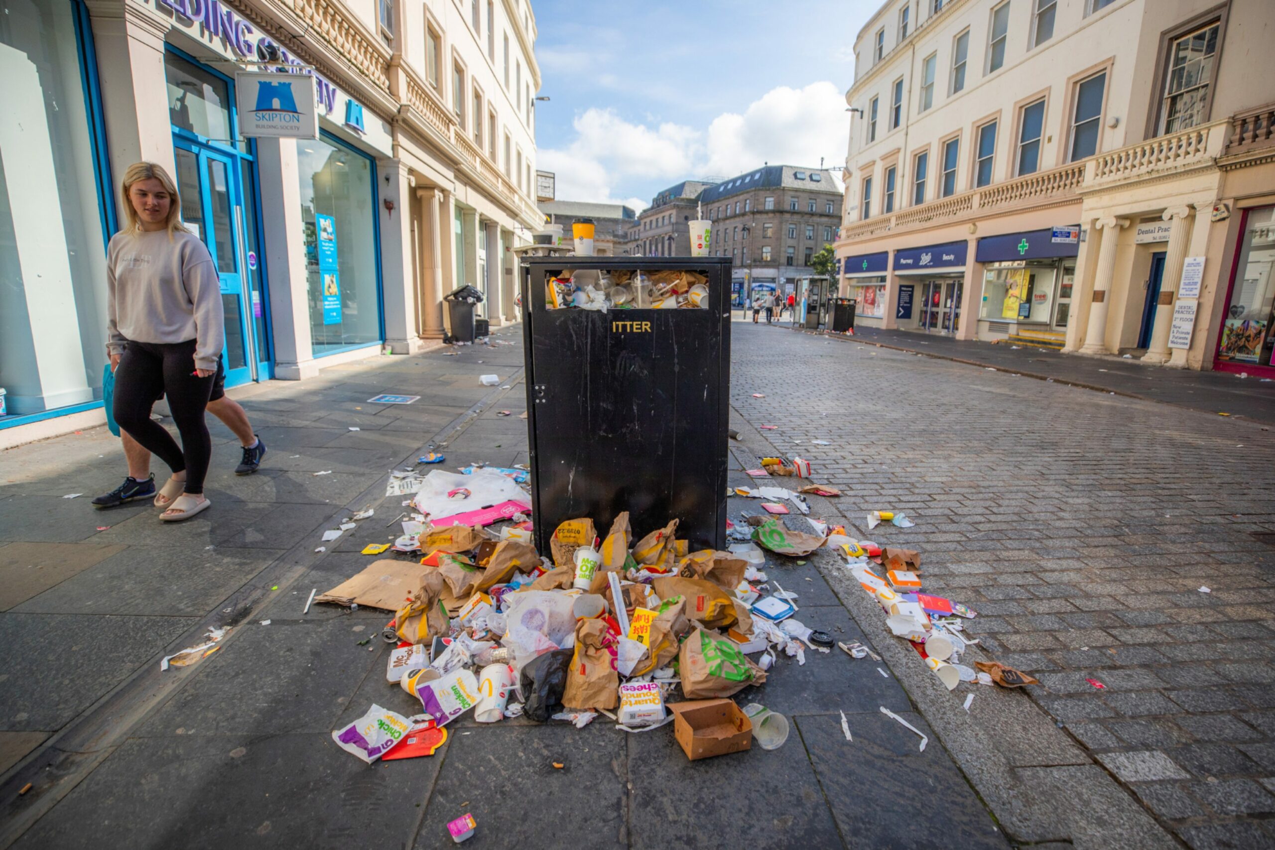 Overflowing bin surrounded by rubbish in Dundee.