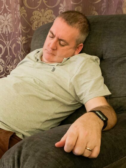 Steven Brown asleep on his sofa.