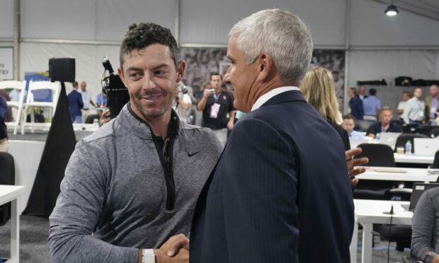 Rory McIlroy shakes hands with PGA Tour Commissioner Jay Monahan.