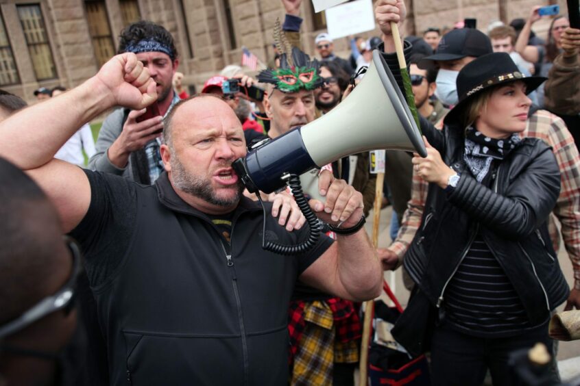 Photo shows Alex Jones shouting into a megaphone at a rally against Covid-19 restrictions in Austin, Texas.