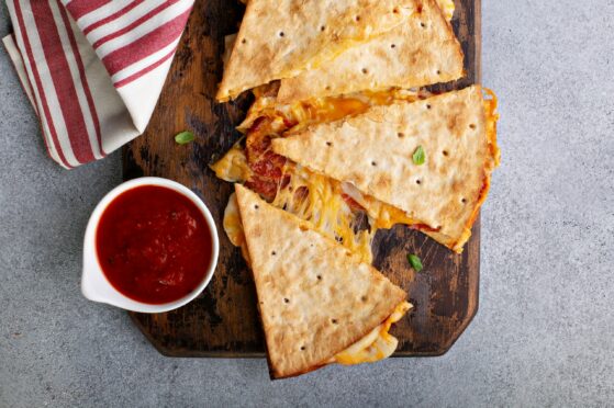 Pizza quesadilla with pepperoni and marinara sauce with cheese pull; Shutterstock ID 1905751312; purchase_order: ; job: