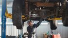 Mechanic checking the underside of a car during an MOT in Dundee