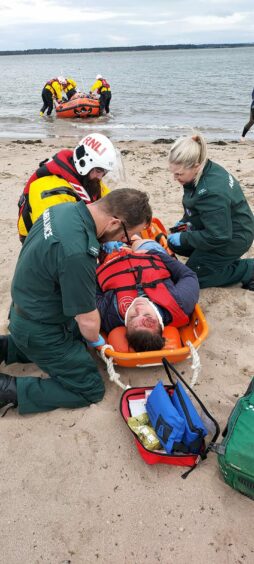 A man on a stretcher being given 'treatment'.
