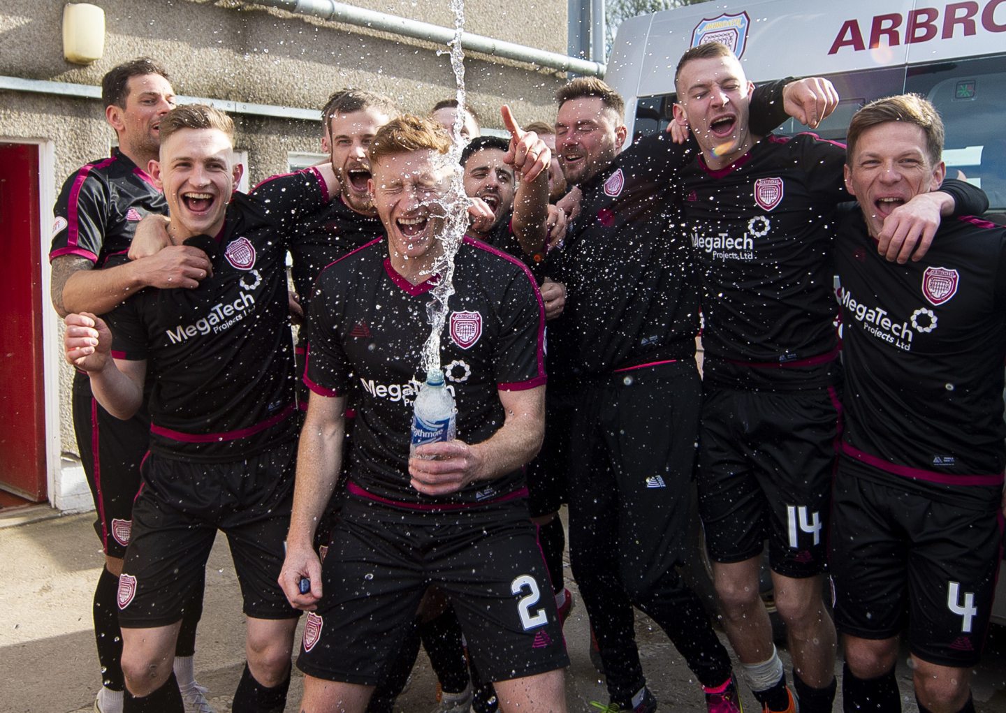 Jason Thomson (2) celebrates with his Arbroath teammates after clinching the League One title.
