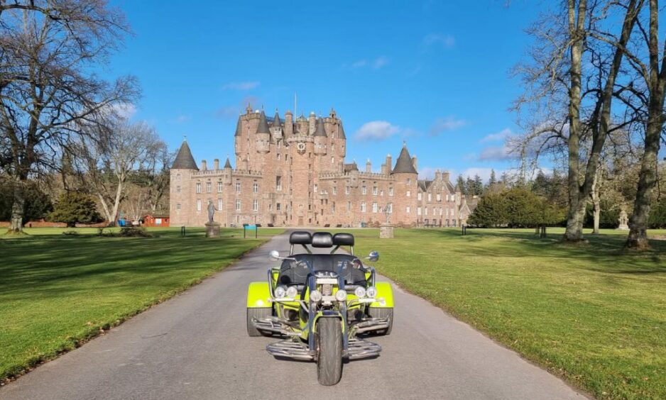 A green trike parked in front of Glamis Castle.