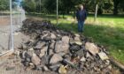 Allan Mara with the piles of rubble on Girvan Gardens, Whitfield