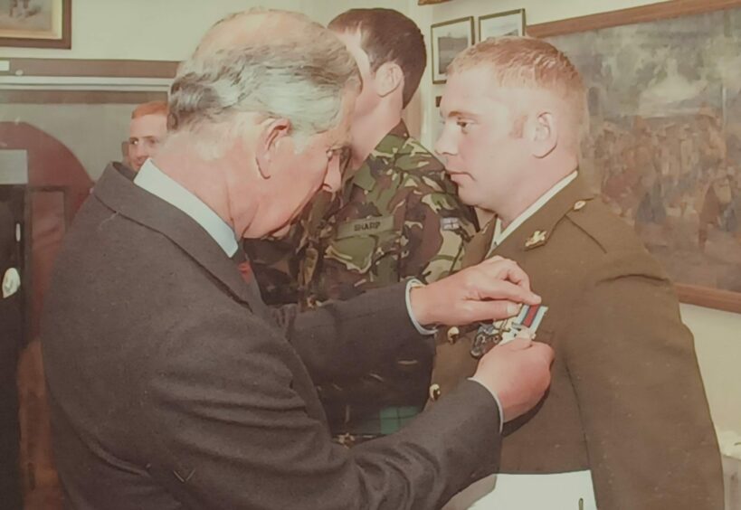 Sam Morgan given a medal by the then-Prince Charles in 2010.