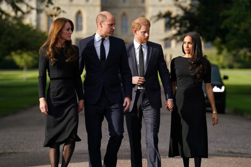 Photo shows the Princess of Wales, the Prince of Wales and the Duke and Duchess of Sussex, dressed in black, as they walk to meet members of the public at Windsor Castle following the death of Queen Elizabeth II