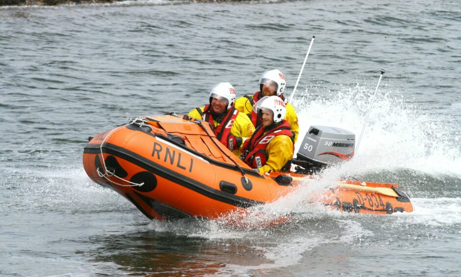 Photo shows three Broughty Ferry lifeboat volunteers on an inflatable boat.