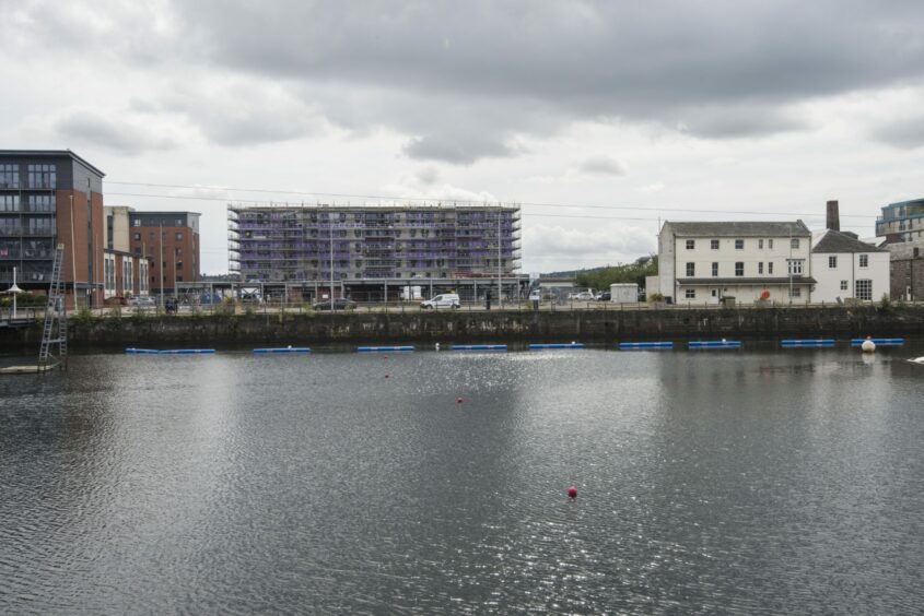 The first block, pictured from Victoria Dock, is under construction. 