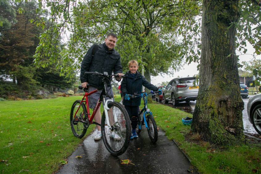 Chris Fox and Freddie Gallacher, 7,  ready for the start with smiles despite the rain.