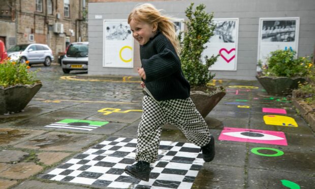 Florence Higgins — artist Catriona Higgins' daughter — enjoys the new mural playground.