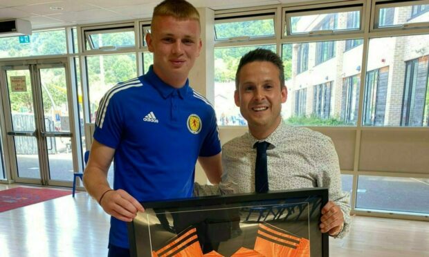 Former Celtic teenage goalkeeper Rory Mahady has donated his first Scotland strip to his old school. He is pictured with Burntisland Primary teacher Danny Hubbard.