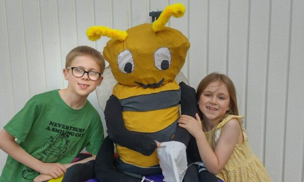 Seth Paterson, 10, and his sister Iris, 7, with their scarecrow. Their clue is 'The most creative member of the hive'.