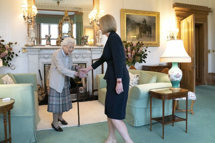 Photo shows the Queen shaking hands with Prime Minister Liz Truss in a sitting room at Balmoral Castle.
