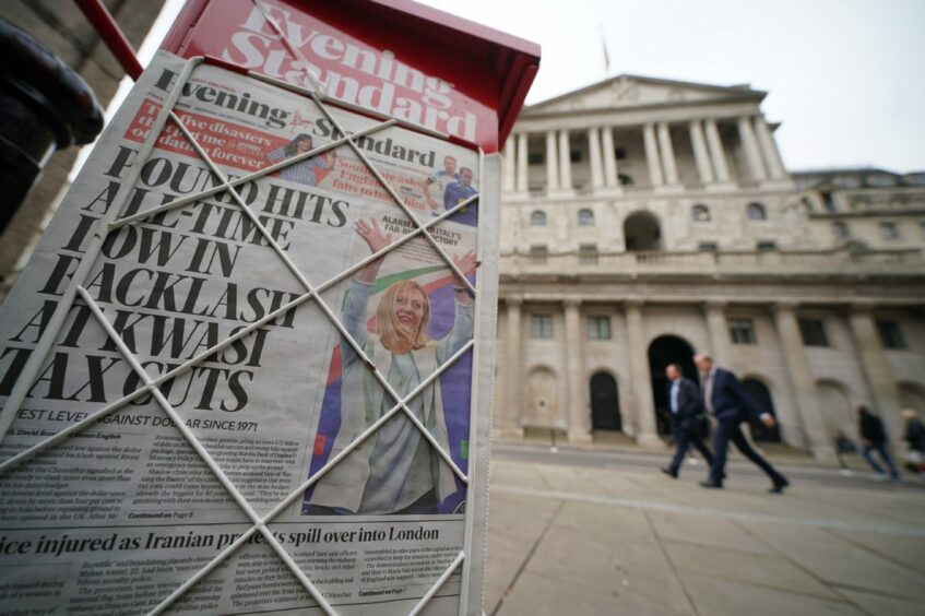 Photo shows a copy of London's Evening Standard on a newspaper seller's stand, with the headline "Pound hits all-time low in backlash at Kwasi tax cuts" on display outside the Bank of England in the city of London.