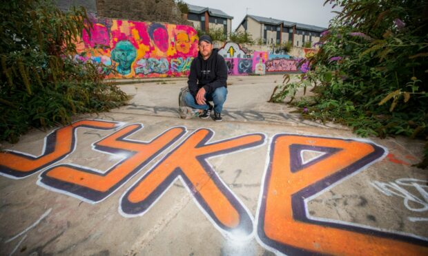 Syke with artwork featuring his own name at an area off Mary Ann Lane in Dundee.