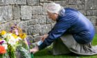 Esther Ferguson from Montrose lays a floral tribute at the gates of Glamis Castle. Pic: Steve Brown/DCT Media.
