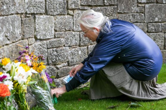 Esther Ferguson from Montrose lays a floral tribute at the gates of Glamis Castle. Pic: Steve Brown/DCT Media.