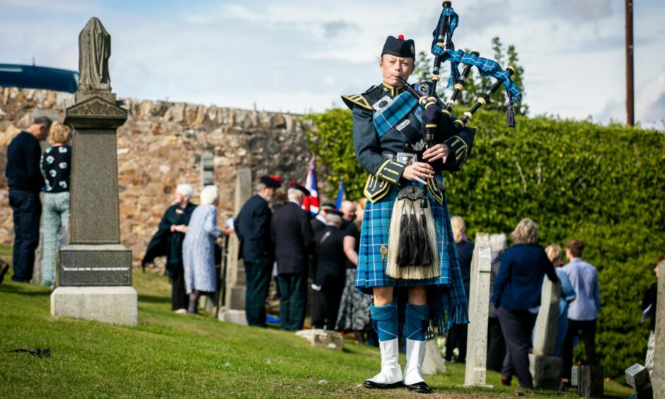 RAF Piper Audrey Clarke from Central Scotland Pipe Band, Leuchars, plays the lament at the Fife soldier's grave