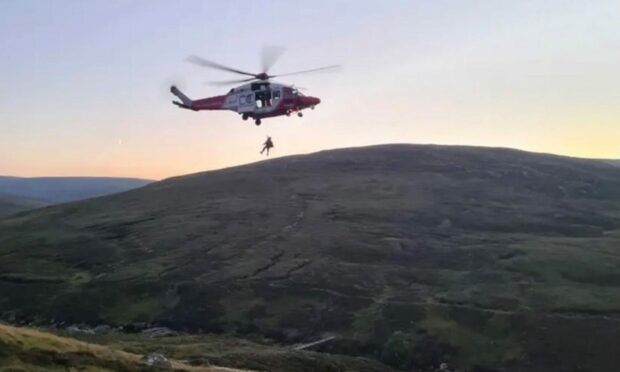 The coastguard helicopter lifting the injured woman to safety.