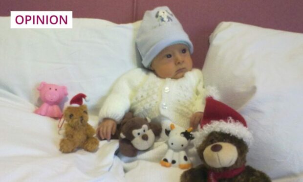 photo shows a baby surrounded by soft toys