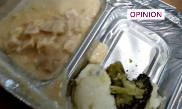 Photo shows an unappetising dish of sauce, a boiled potatoe and an overcooked broccoli floret in a foil tray.