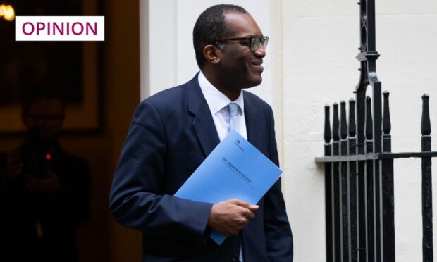Photo shows the Chancellor Kwasi Kwarteng walking out of the door of his Downing Street residence.