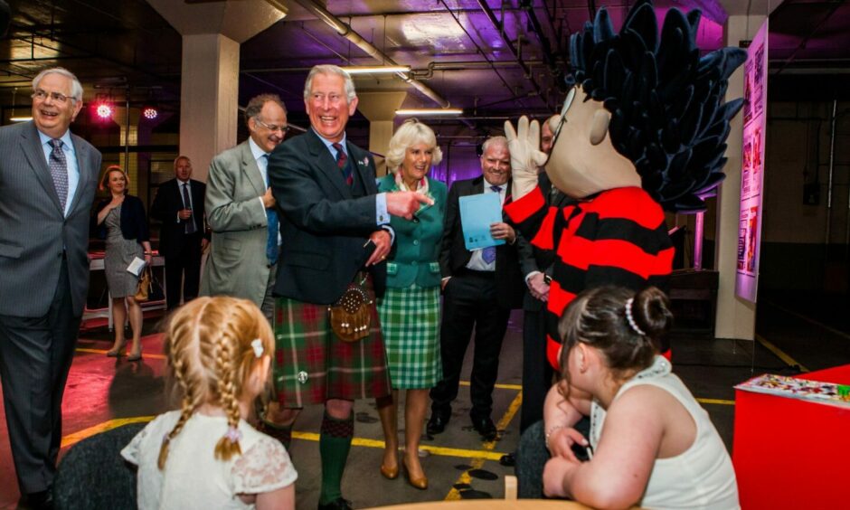 King Charles and Queen Camilla meeting a Dennis the Menace statue on a visit to DC Thomson's printing plant in Dundee.