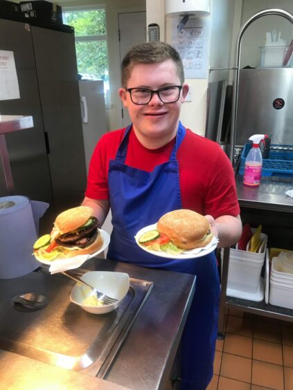 Aaron helps make the burgers and sandwiches at Kinross Golf Club.