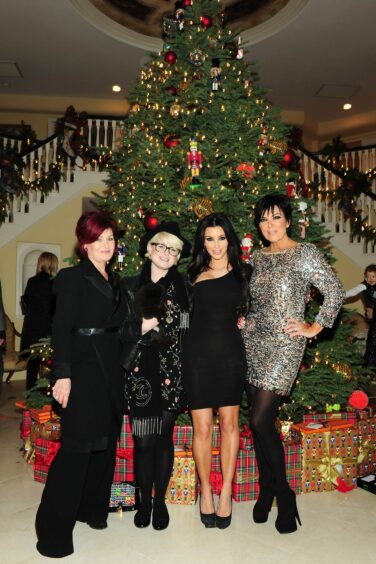 photo shows Sharon and Kelly Osborne, Kim Kardashian and Kris Jenner in front of a Christmas tree.