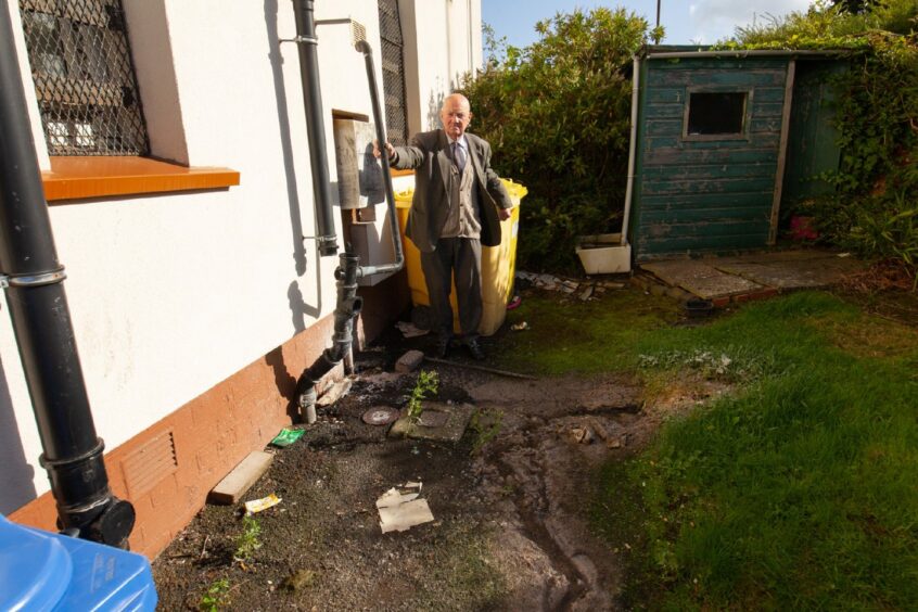 Stuart Garland holds up broken pipe.