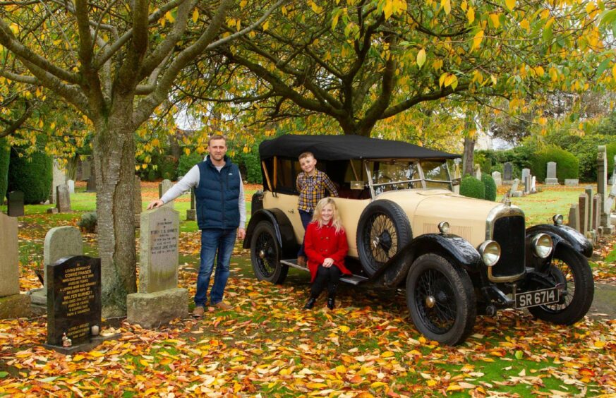 Phil Barnett and his children Bravely, 10, and Gregor, 7, with their 95-year-old Lagonda 14/60 at the graves at Arbroath's Western Cemetry.