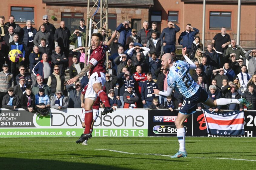 Zak Rudden heads in a goal for Dundee against Arbroath in the Championship last season as opponent Ricky Little jumps in front of him. 