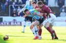 Dundee's Jordan McGhee holds off two Arbroath opponents (Image: SNS)