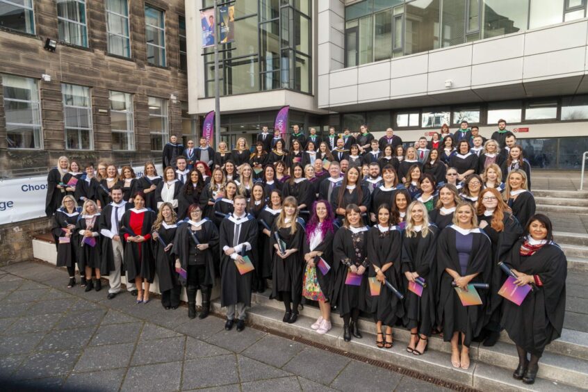 Fife College graduates pose in their togas and diplomas on graduation day. Fife College is an affordable college for many students