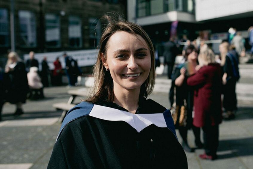 Aleksandra Ogorzalek smiles as she wears her toga on graduation day. She finished her course at Fife College, an affordable college for students