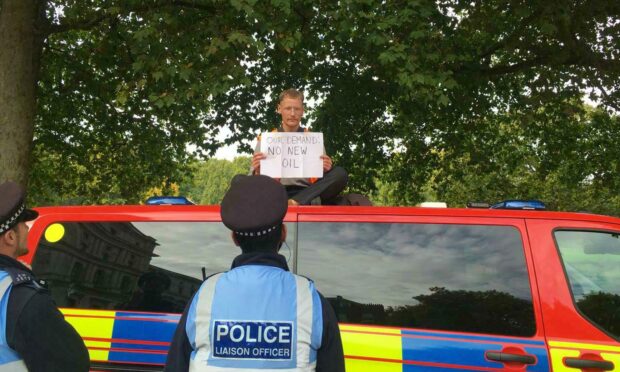 Dan Johnson protests on top of the police van.