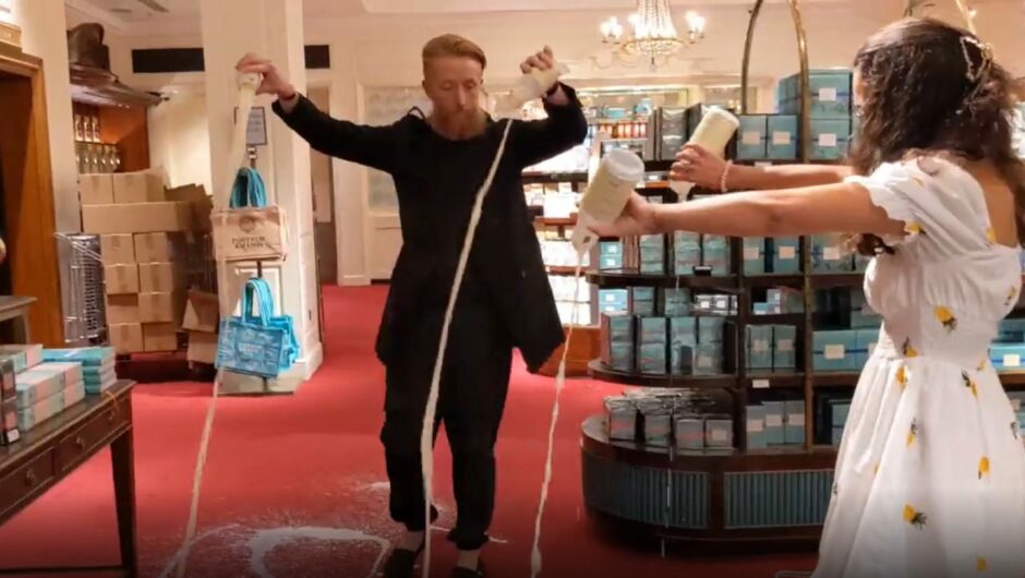 photo shows a man and woman pouring milk over the carpet in a Fortnum and Mason store.