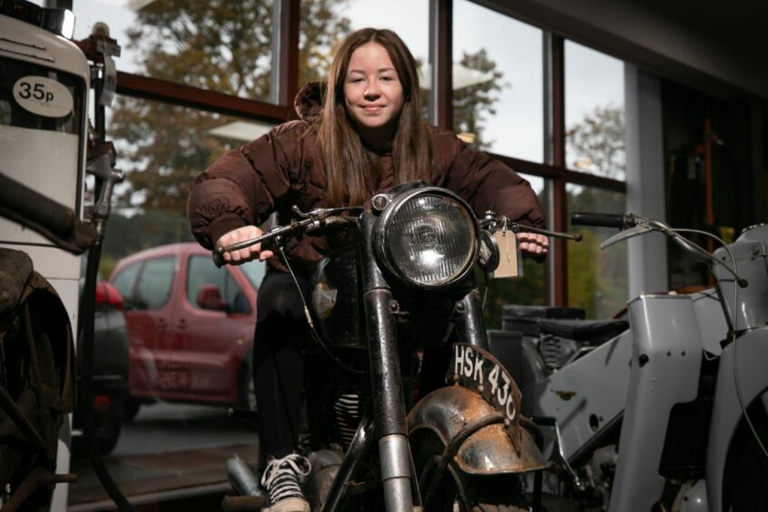 Teenager Katy Hogg on one of the restoration project motorcycles in the Glamis auction.