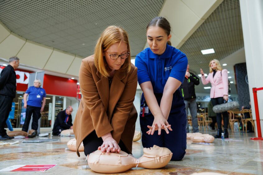 Karen Ford takes Cara Forrester through the life-saving CPR training. 