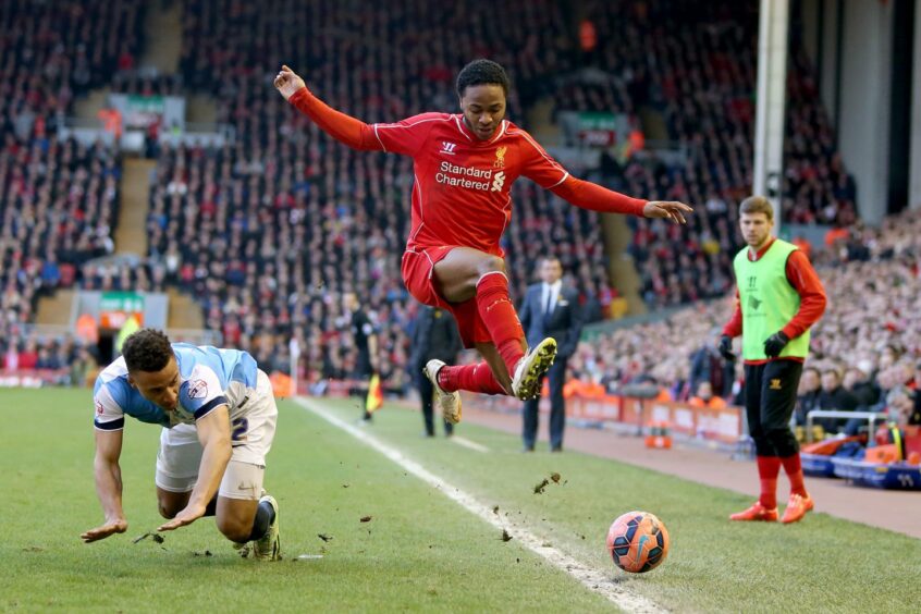 Liverpool's Raheem Sterling hurdles a challenge from Blackburn Rovers' Adam Henley, left, during the FA Cup Sixth Round match at Anfield, Liverpool. Then-Blackburn boss Gary Bowyer is in the background. Image: PA.