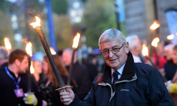 Allan Campbell, president of An Comunn Gaidhealach led the torchlight procession through the city. Image: Sandy McCook/ DC Thomson.