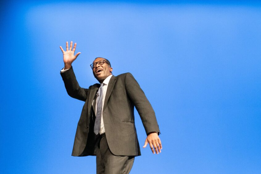 Photo shows UK Chancellor Kwasi Kwarteng against a blue background at the Conservative Party conference.