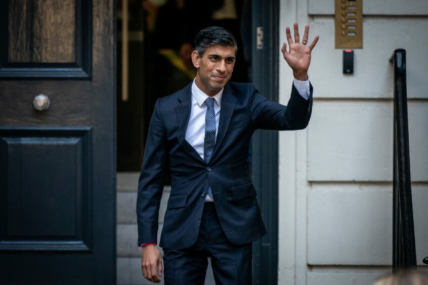 Photo shows Rishi Sunak waving from the steps of Conservative Campaign HQ.