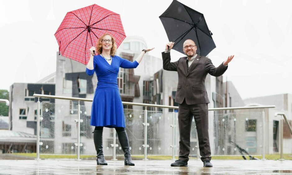 Scottish Greens co-leaders Lorna Slater and Patrick Harvie holding umbrellas outside Dynamic Earth in Edinburgh