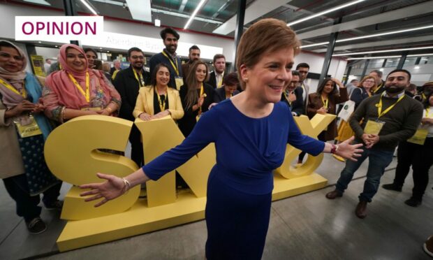 photo shows Nicola Sturgeon in front of a large SNP sign, surrounded by supporters at the party conference in Aberdeen.