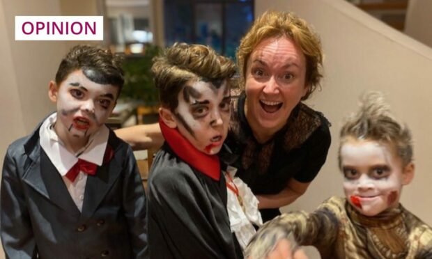 photo shows Martel Maxwell with her three sons dressed as ghosts and vampires for Halloween.