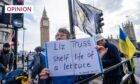 Photo shows a protester in Parliament Square holding a placard which says 'Liz Truss - shelf life of a lettuce'.